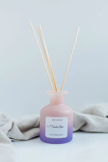 Timeless Organics Midsummer Night reed diffuser on a table beside folded linen