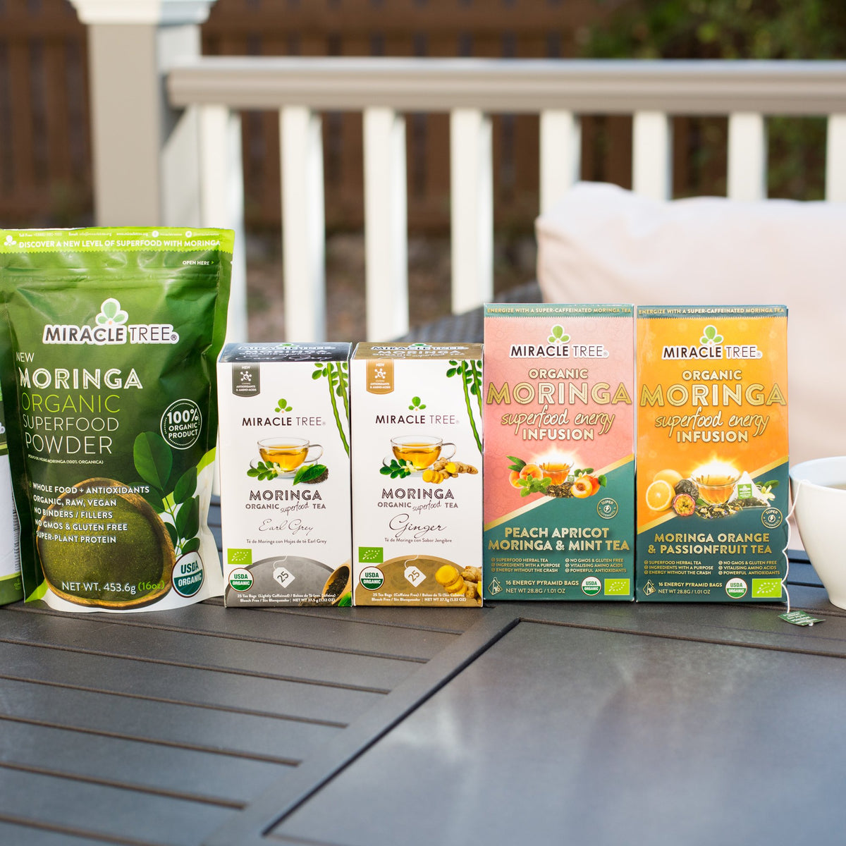 Miracle Tree moringa powder, herbal teas and energy teas on a patio table