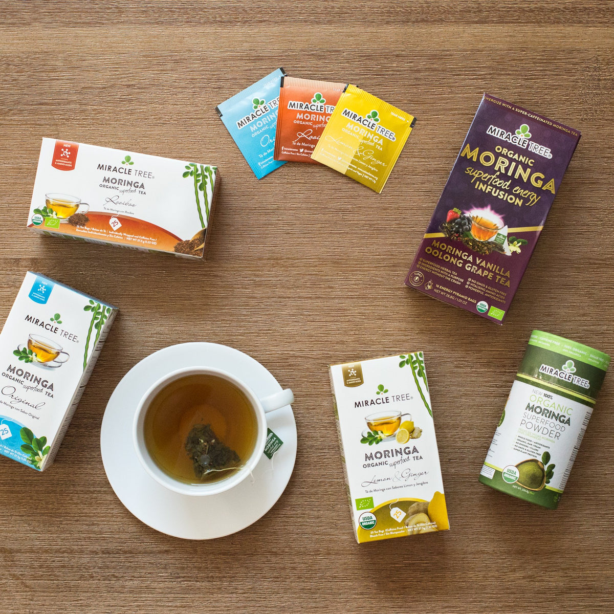 Miracle Tree moringa teas, tea bags and superfood powder on a wooden table