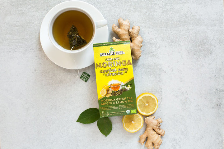 Ginger Lemon moringa energy tea box with ginger root, lemon and a cup of tea.
