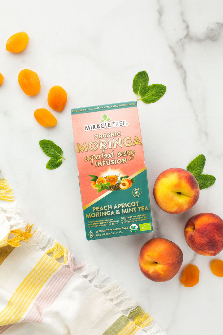 Peach Mint Apricot moringa energy tea box with peaches, apricots and mint leaves.