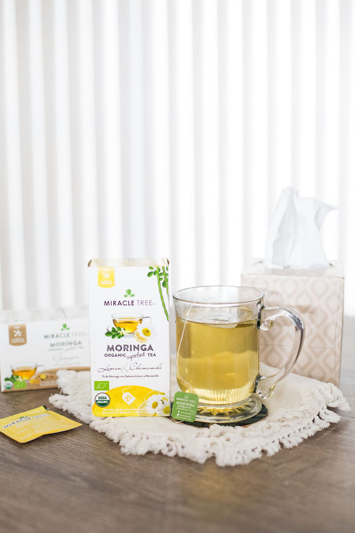 Lemon & Chamomile moringa tea box next to a mug of tea.